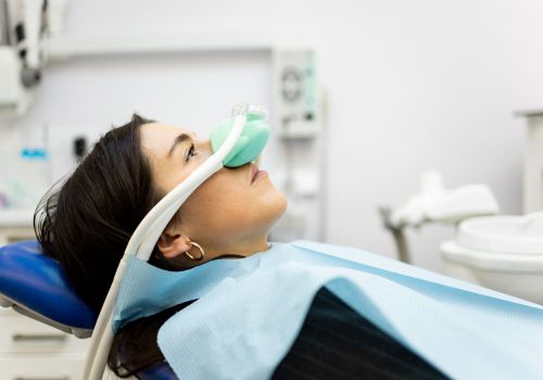 Woman wearing sedation mask to receive laughing gas for dental anxiety during a procedure